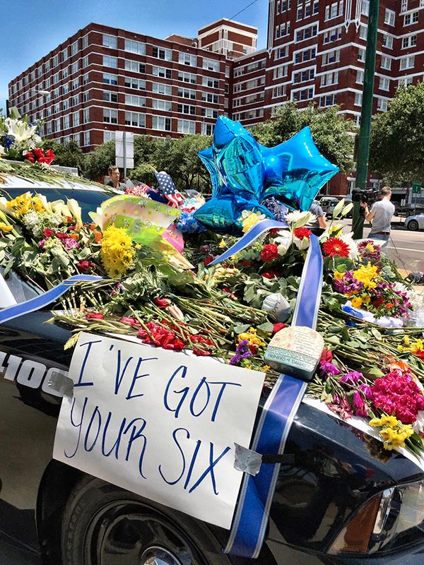 För att hedra offren lägger människor blommor utanför polishuset i Dallas.