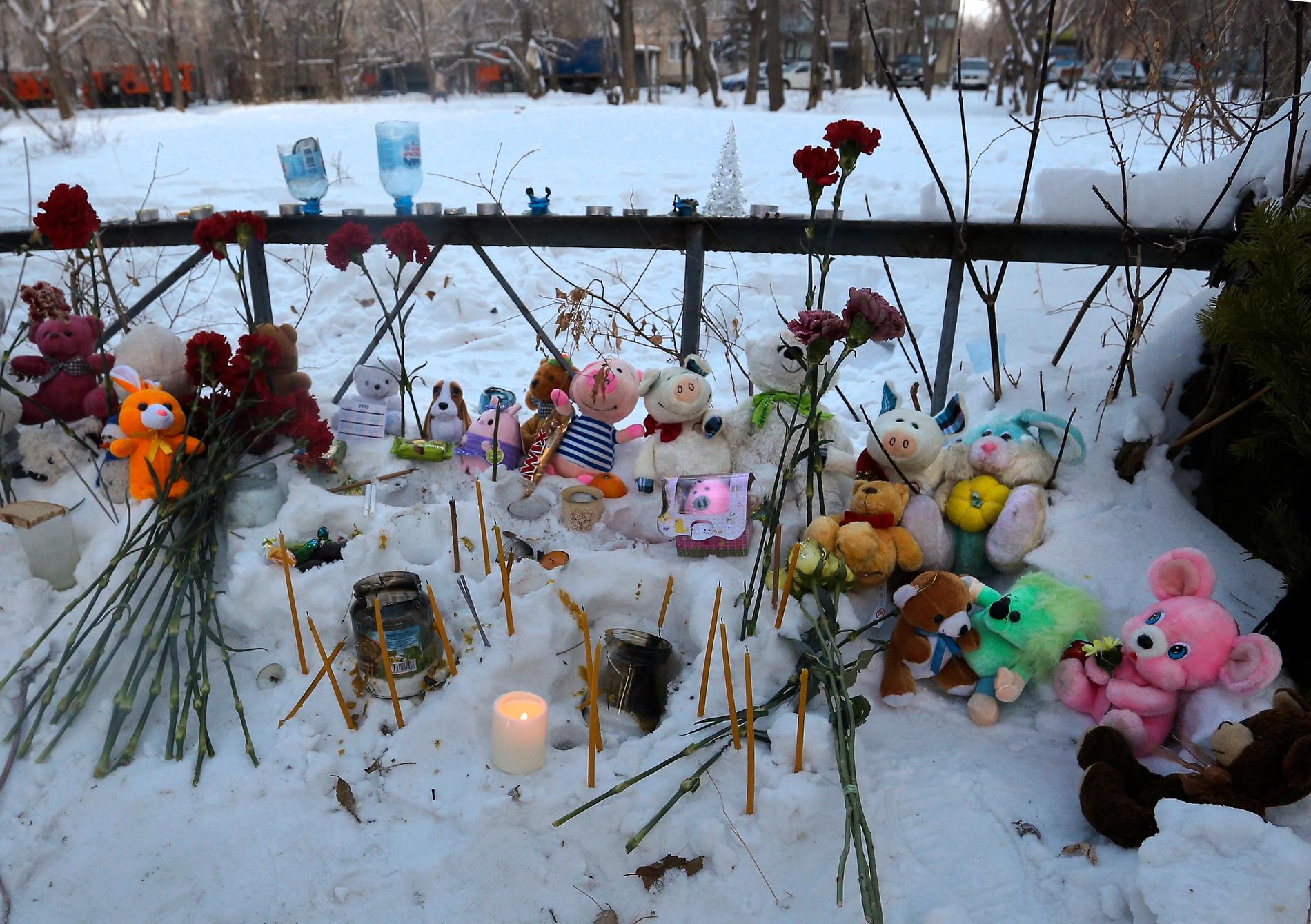 Blommor och leksaker har placerats i närheten av raset för att hedra de döda och skadade.