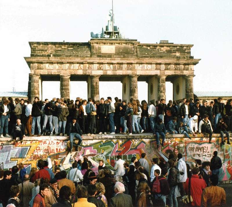 Tyskar på muren vid Brandenburger Tor en dag efter att muren öppnades.