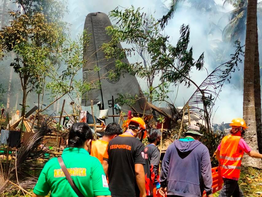 Räddningsarbetare vid nedslagsplatsen. Minst 40 personer räddades ur det brinnande vraket, uppger filippinska tjänstemän.