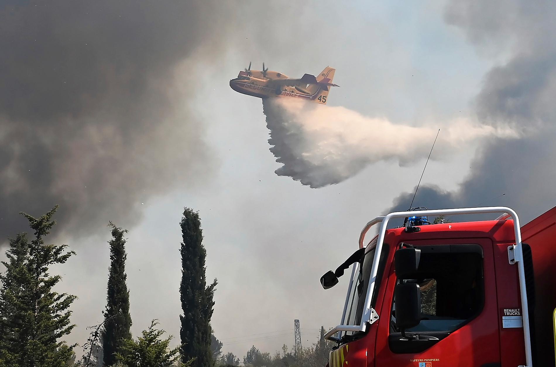 Flera våldsamma bränder har brutit ut i Frankrike i hettan. Fyra brandmän skadades i en skogsbrand i den södra franska regionen Gard. Här ett vattenbombningsplan över en annan skogsbrand i Aubais, i södra Frankrike, den 31 juli 2022. 