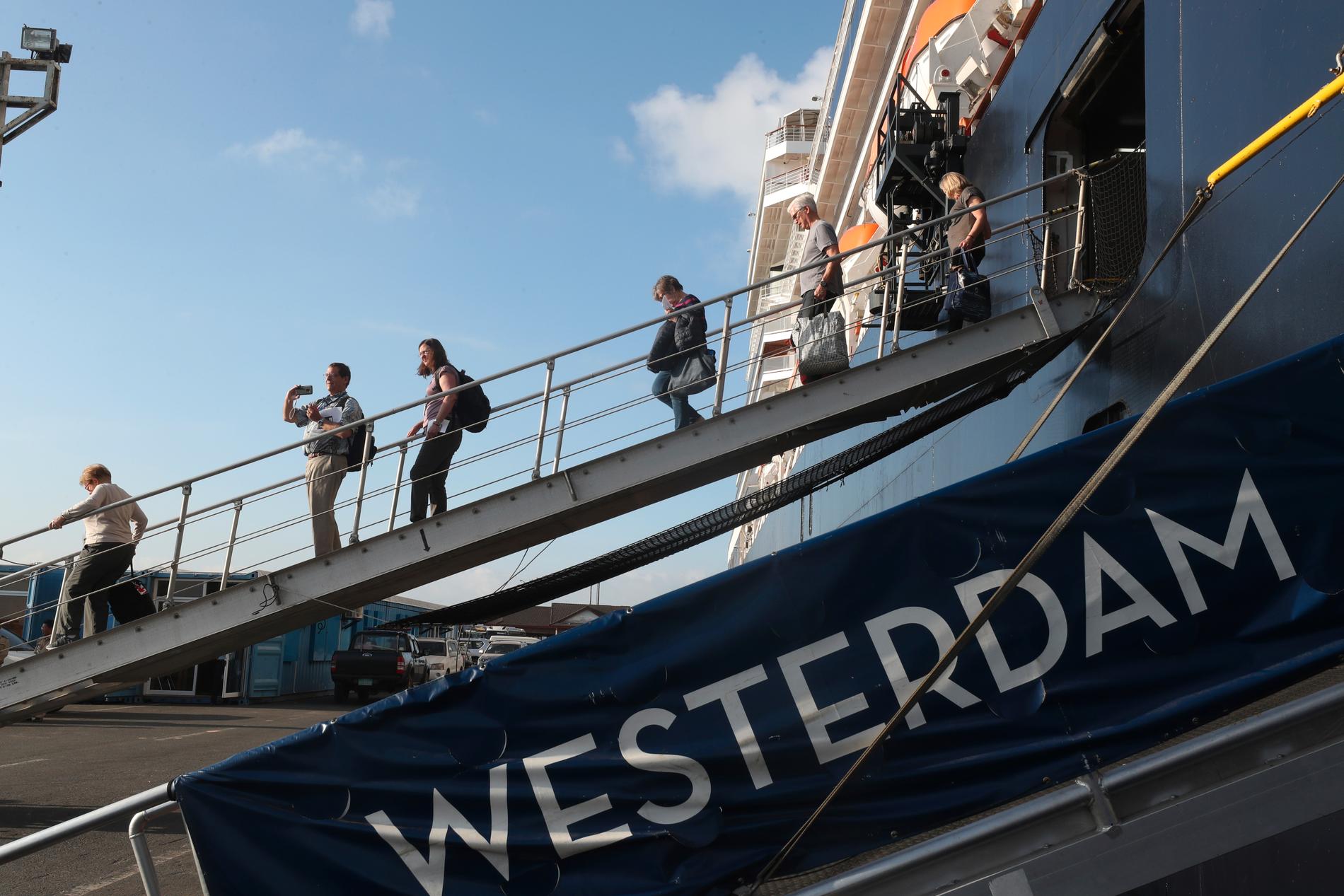 Passagerare lämnar kryssningsfartyget MS Westerdam som lagt till i Kambodja.