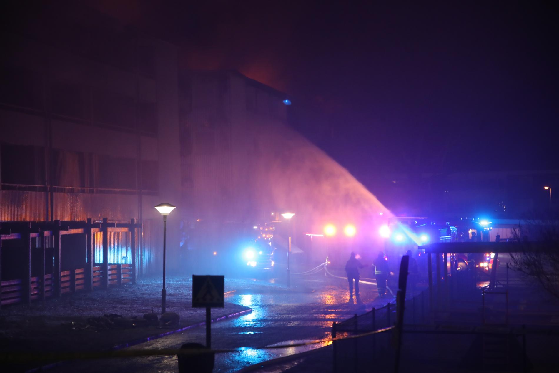 En kraftig brand rasar sedan tisdagskvällen i ett flerfamiljhus i Skövde. Boende i mellan 90 och 100 lägenheter har evakuerats.