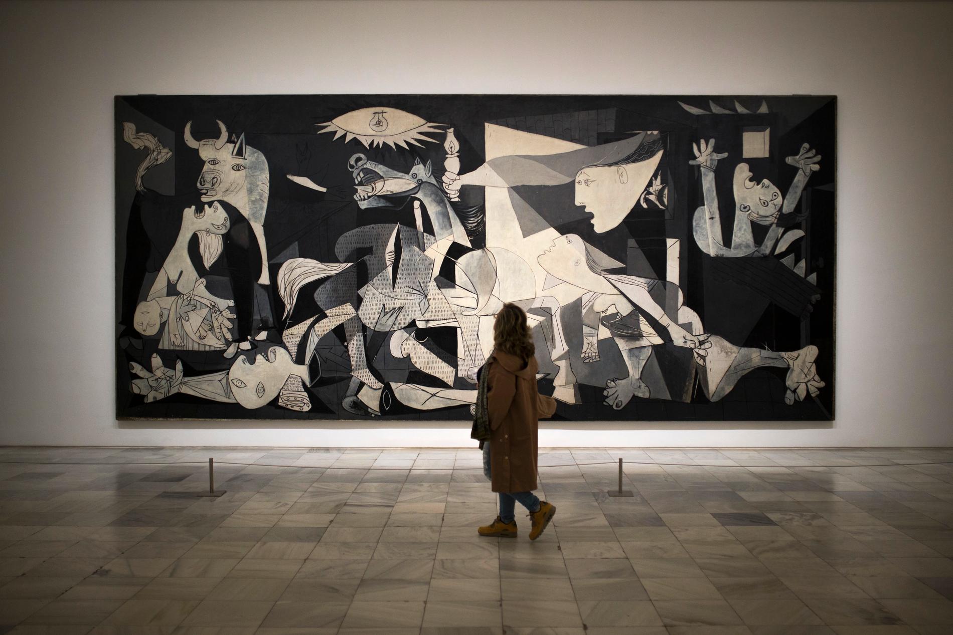 En kvinna tittar på Pablo Picassos originalmålning "Guernica". Arkivbild.
