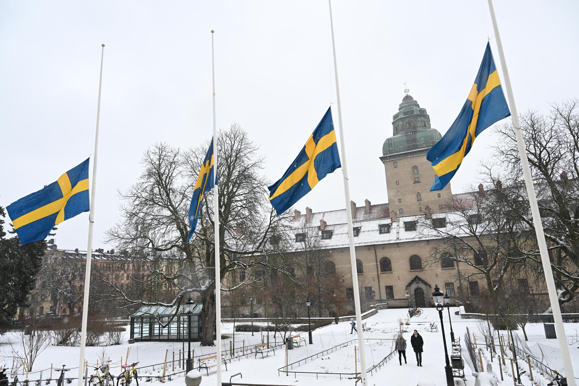 Flaggor på halv stång vid polishuset i Stockholm. Klockan 12 på torsdagen höll Polismyndigheten en tyst minut med anledning av Mats Löfvings bortgång.