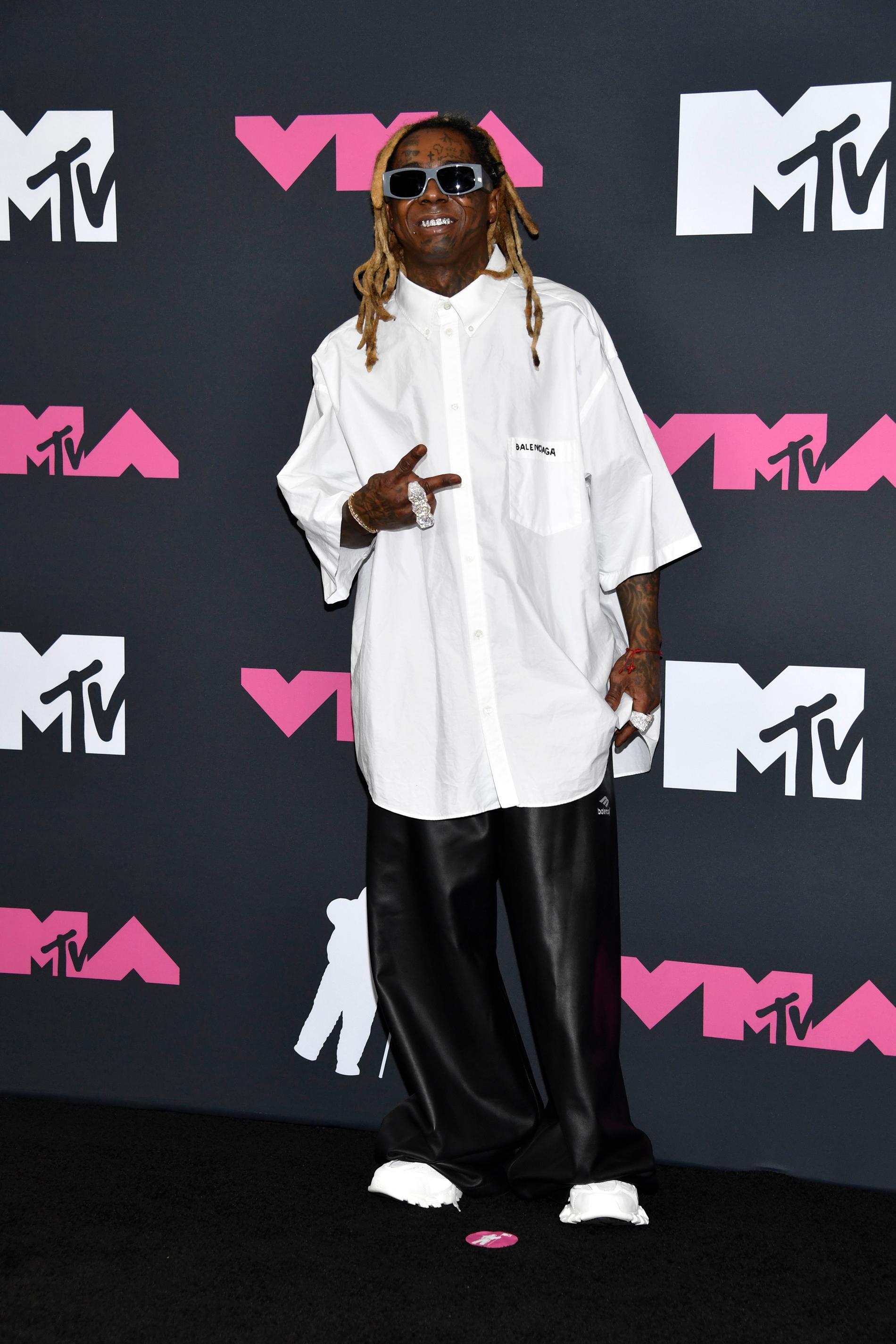 Lil Wayne i en stor vit skjorta med skinnbyxor.
