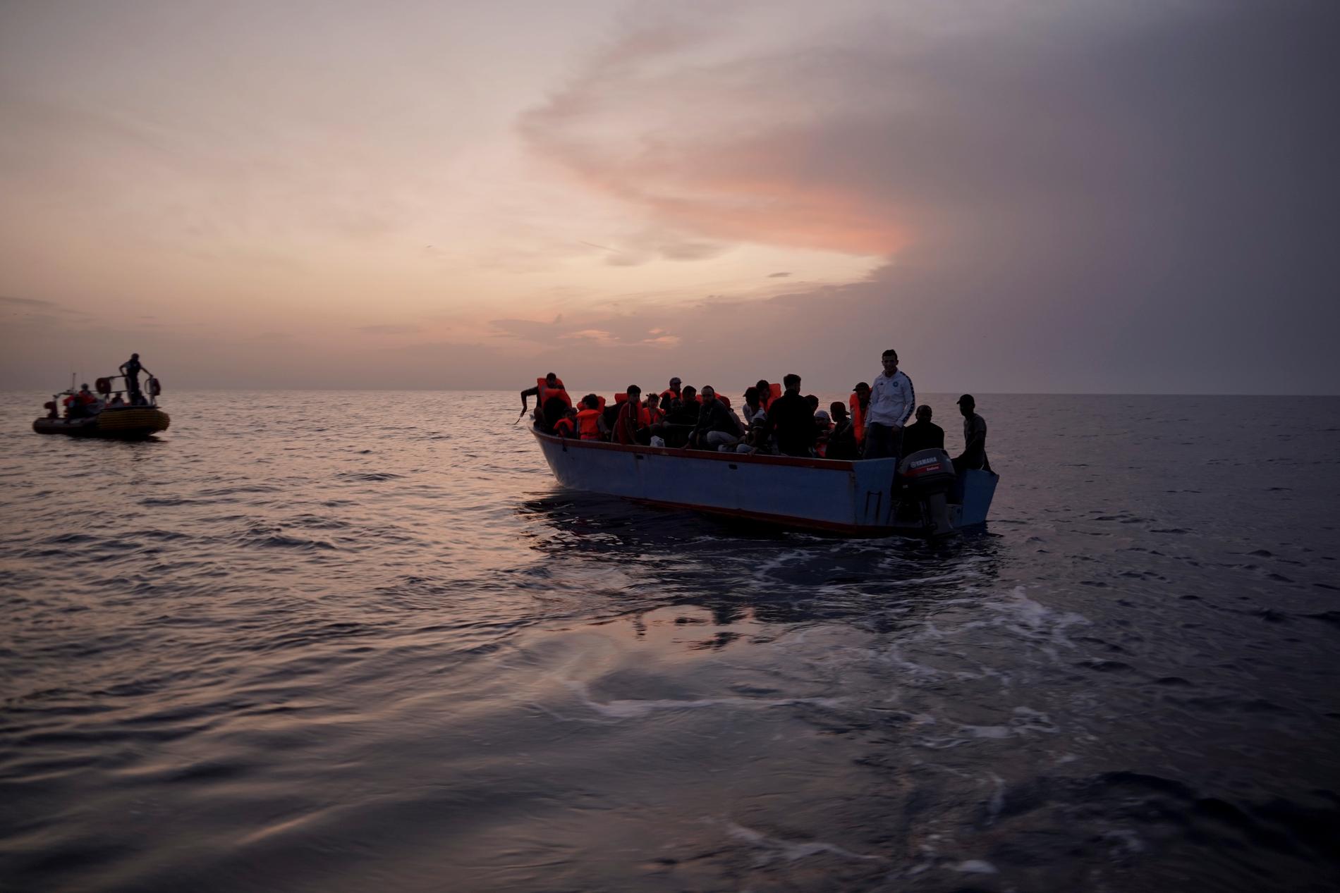 Migranter på en överfull båt på Medelhavet väntar på att bli räddade.