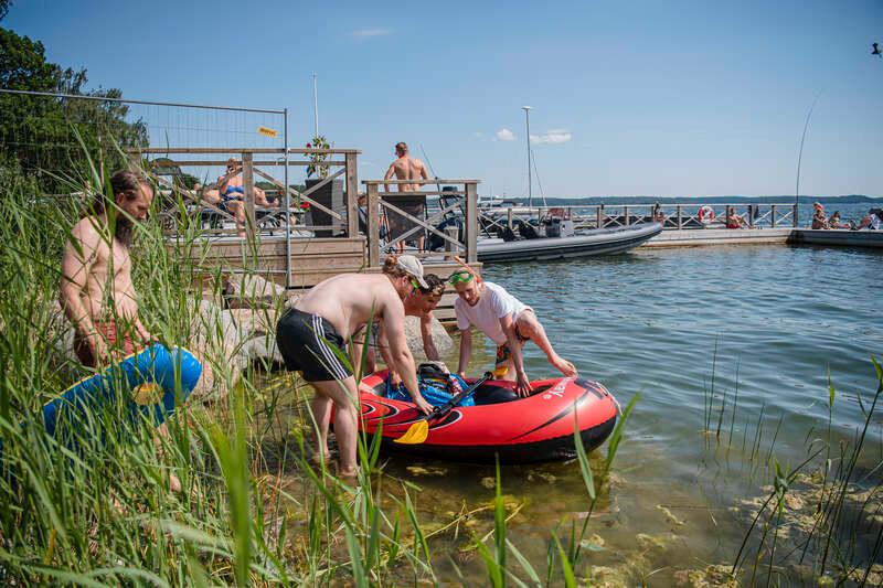 Ett 50-tal personer badar i protest på Drakskeppsvägen i Täby där många hus har bryggor som ligger på allmän mark. 