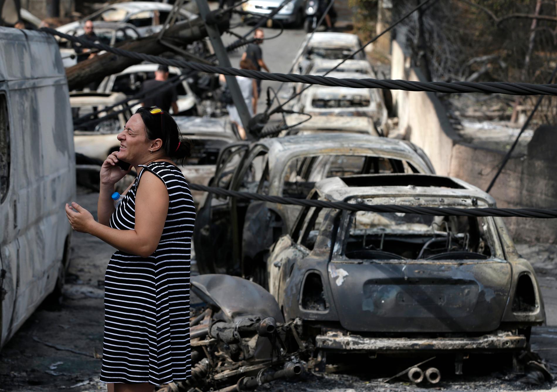 Utbrända bilvrak kantar gatorna i Mati öster om Aten.