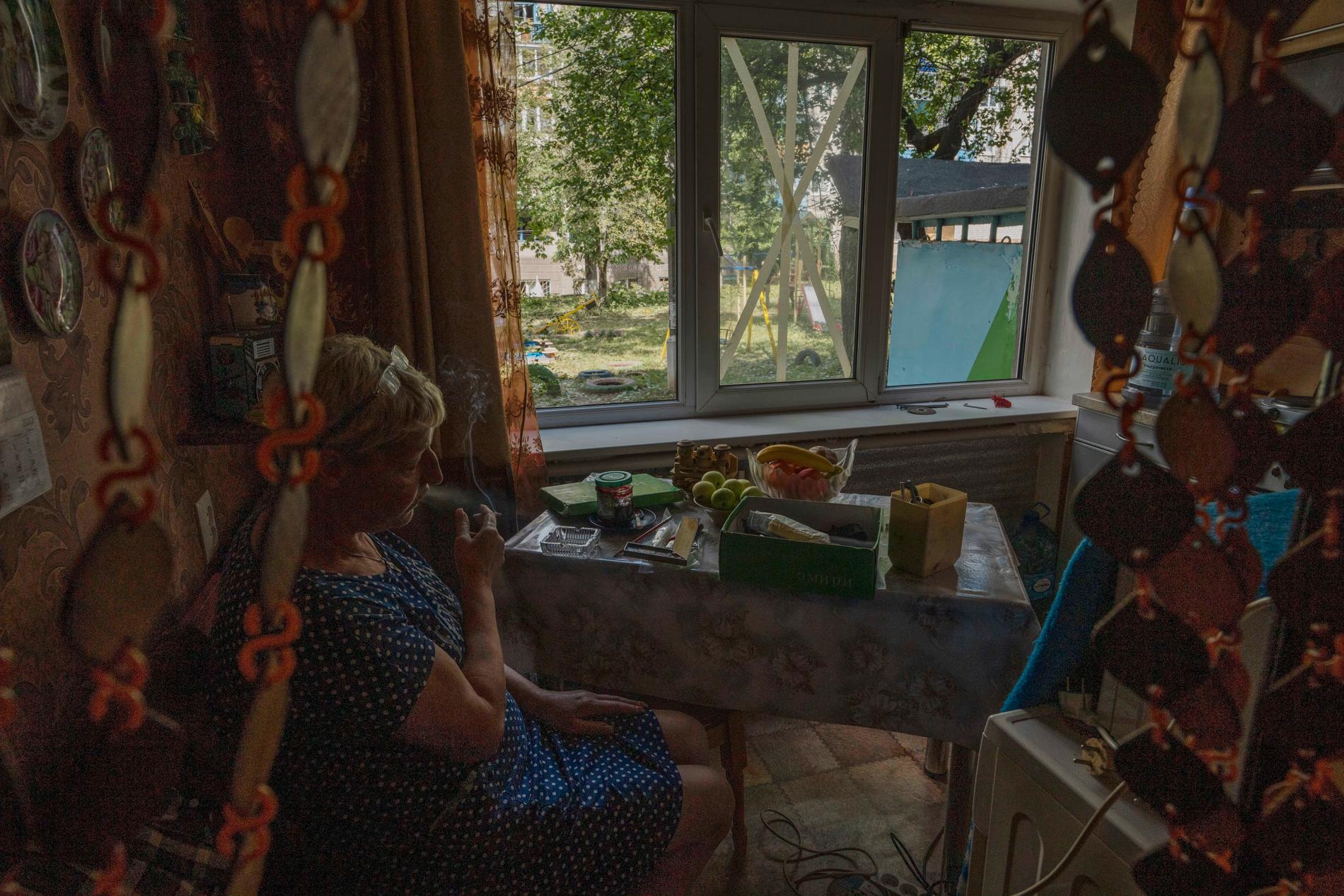 En kvinna röker i sitt kök efter att ett fönster har skadats under en raketattack i staden Kramatorsk, östra Ukraina. 