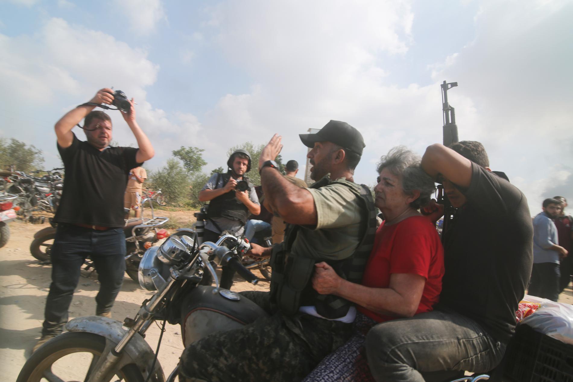 Kvinnan mellan de två männen på motorcykeln är ytterligare en av alla de människor som togs gisslan från Israel under den första dagen av kriget.