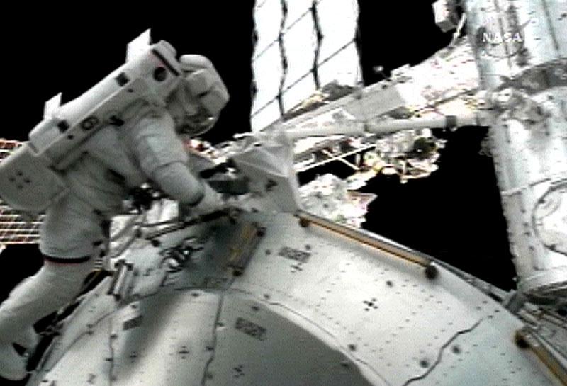 Rick Linnehan arbetar med en robot på den internationella rymdstationen ISS.