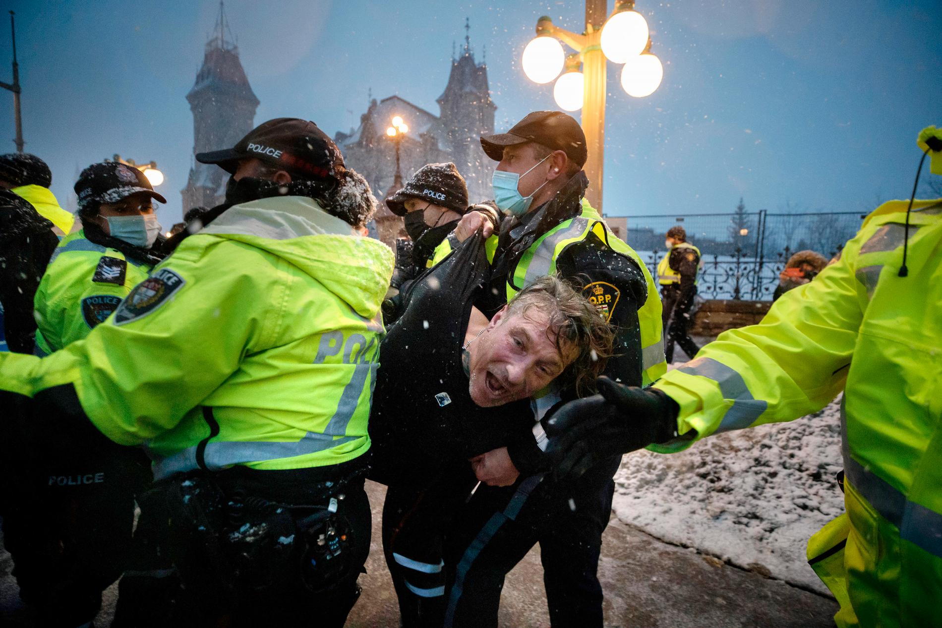 En man arresteras av polis under protesterna i Ottawa.