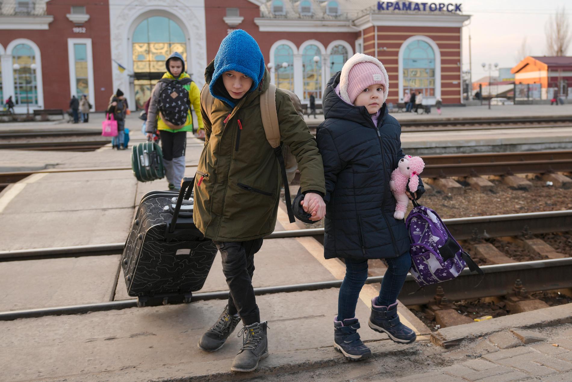 Två barn håller varandra i händerna i Kramatorsk i östra Ukraina på torsdagen. De ska kliva på ett tåg västerut, mot huvudstaden Kiev.