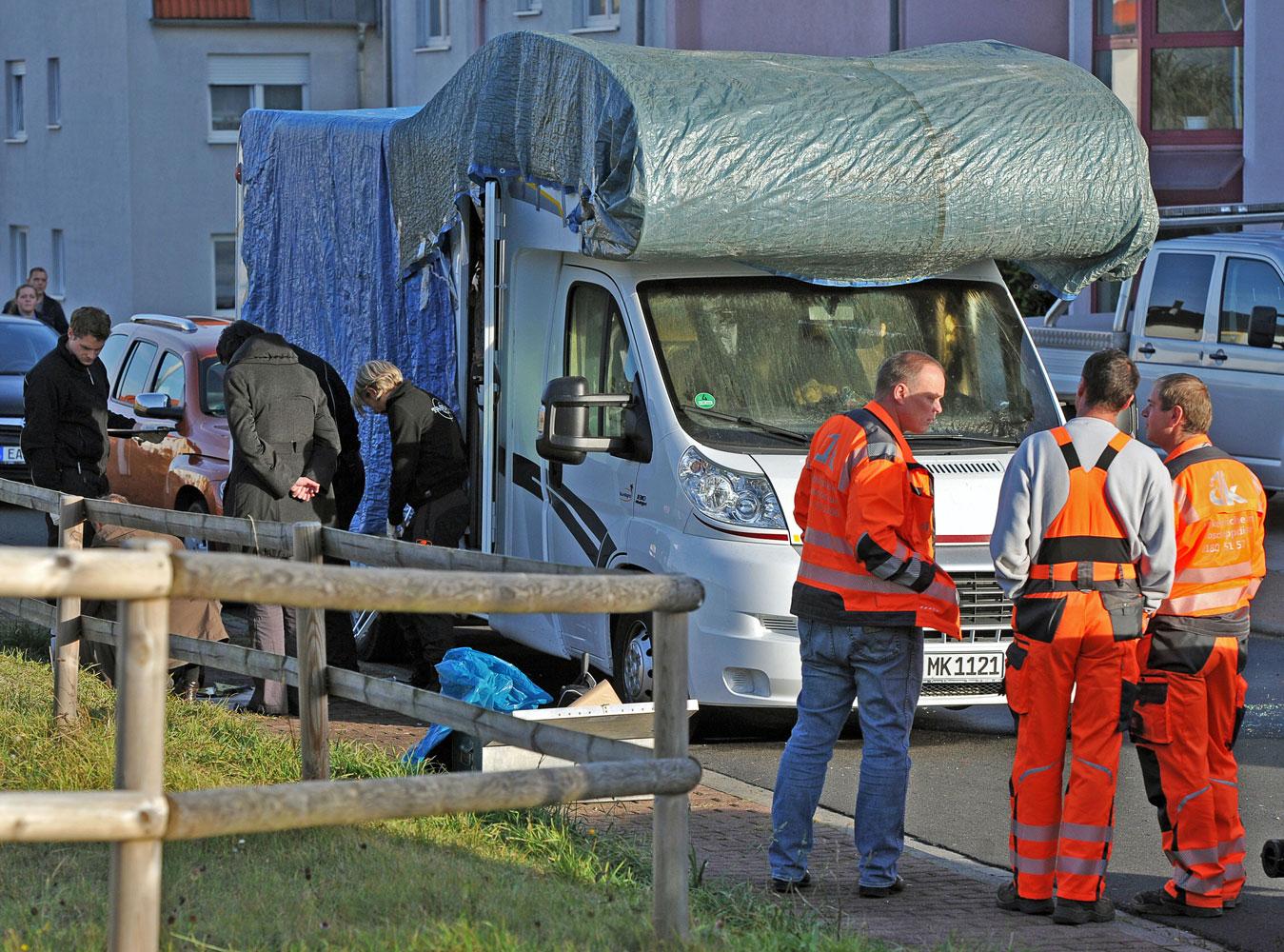 Polisens tekniker undersöker den utbrända husbilen där Uwe Mundlos och Uwe Böhnhardt gömt sig.