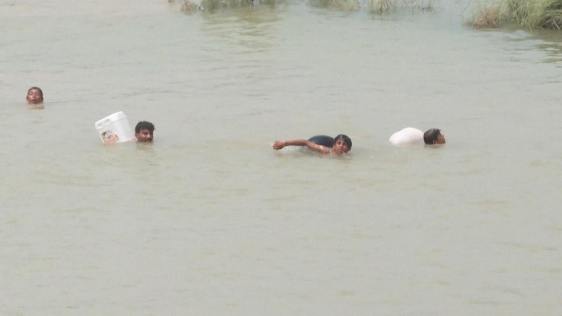 En familj simmar från en torr markplätt där de sökt skydd för att försöka hitta rent vatten. 