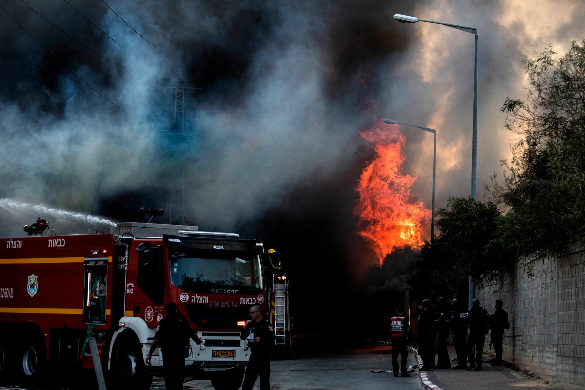 Brandkår bekämpar en brand som bröt ut i en fabrik i israeliska Sderot, efter att en raket träffat byggnaden.