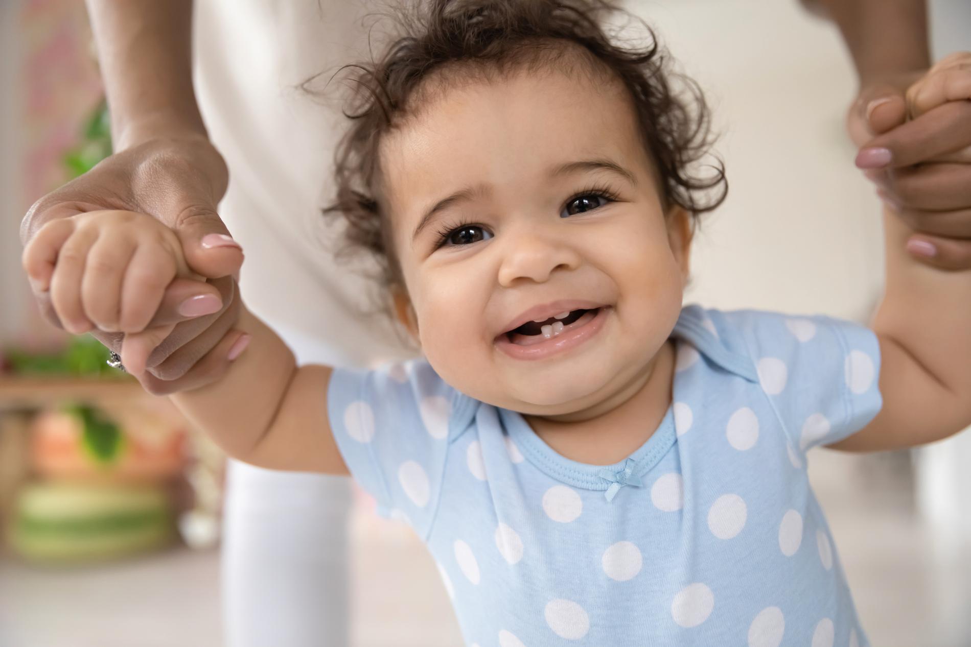 Flickan på bilden med sina första tänder. Barn får vanligen sina första tänder någon gång vid sex till åtta månaders ålder, enligt tandläkaren Lina Granqvist.