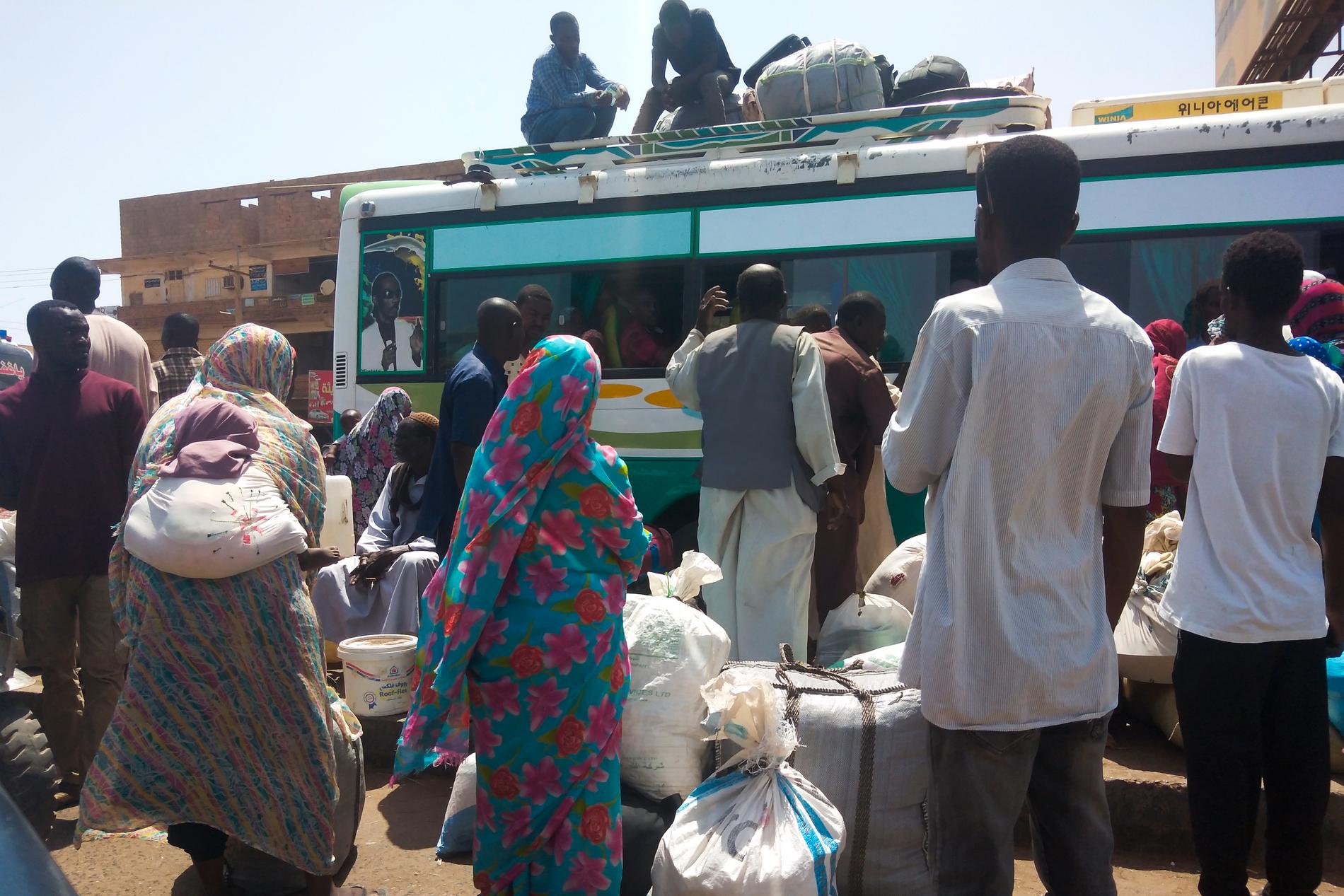 Människor kliver på en buss i Khartoum för att lämna staden.