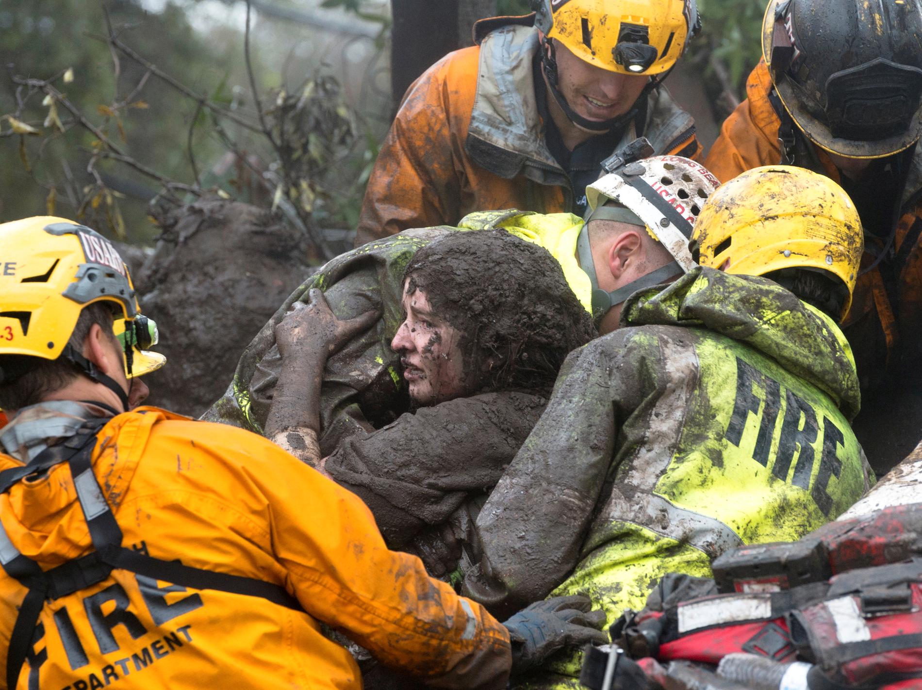 Räddningspersonal räddar en kvinna ur ett kollapsat hus.