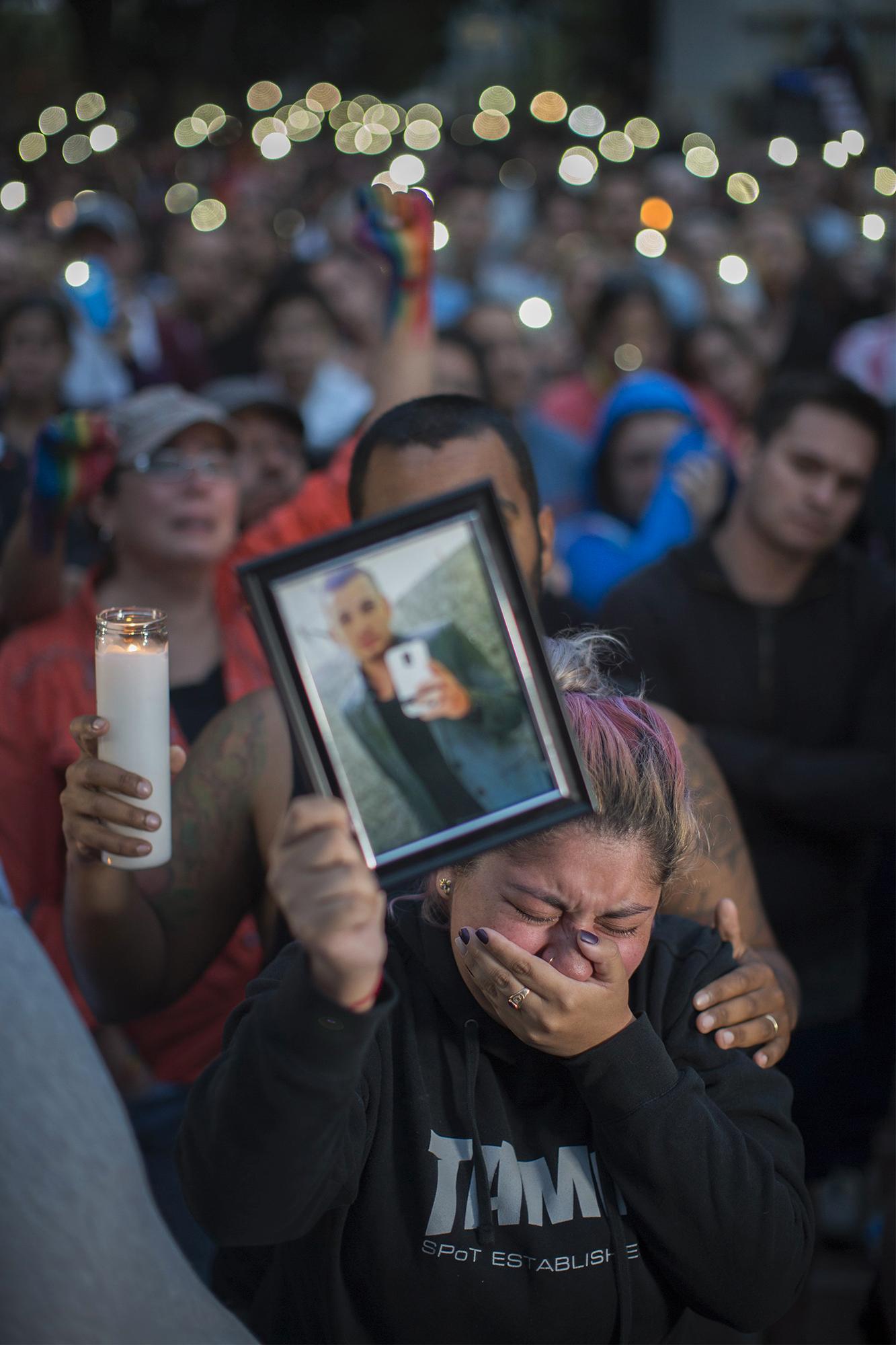 Alison Cosio håller upp en bild av  Christopher Sanfeliz spom sköts till döds på nattklubben Pulse i Orlando.
