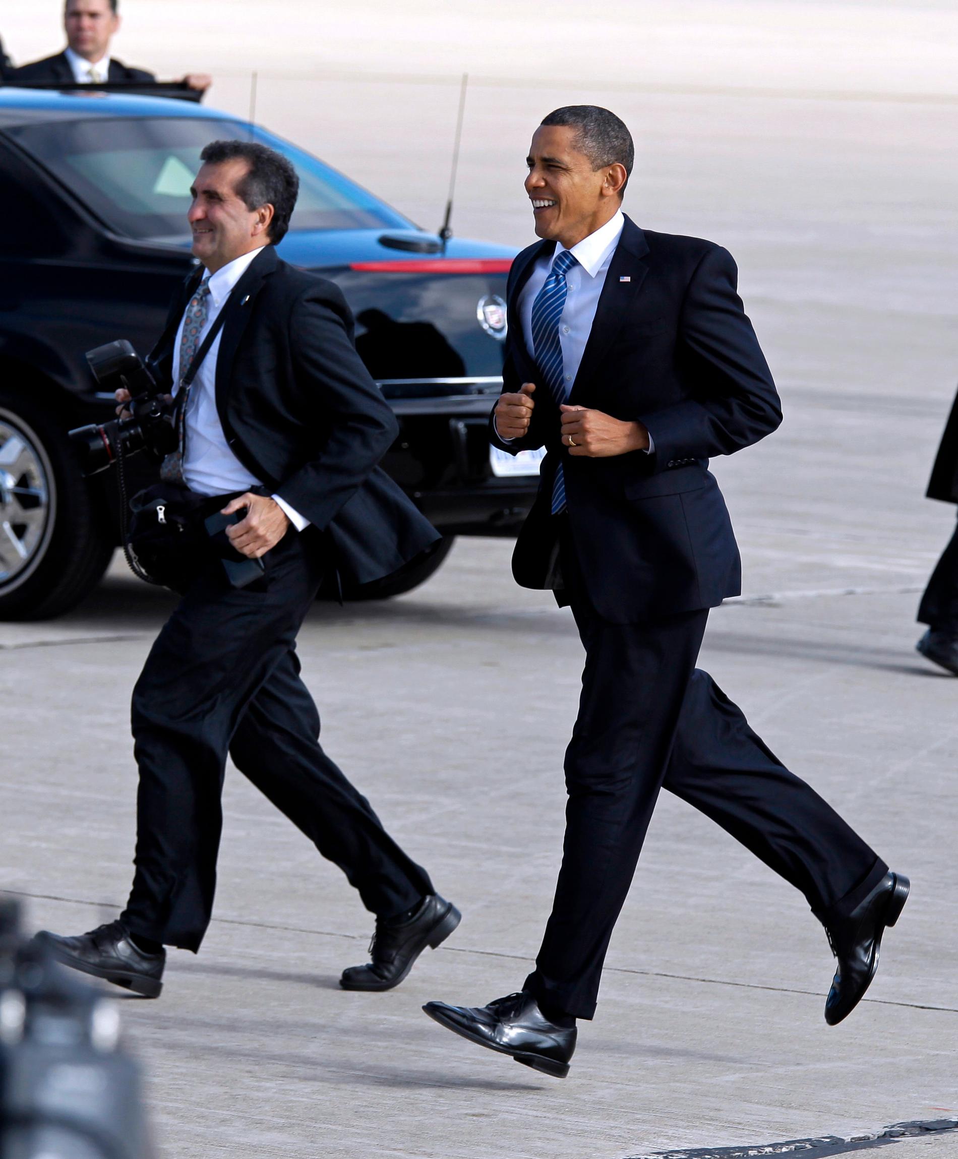 President Barack Obama joggar lätt tillsammans med Vita husets officielle fotograf Pete Souza, efter att ha landat med Air Force One på Grissom Air Reserve Base.