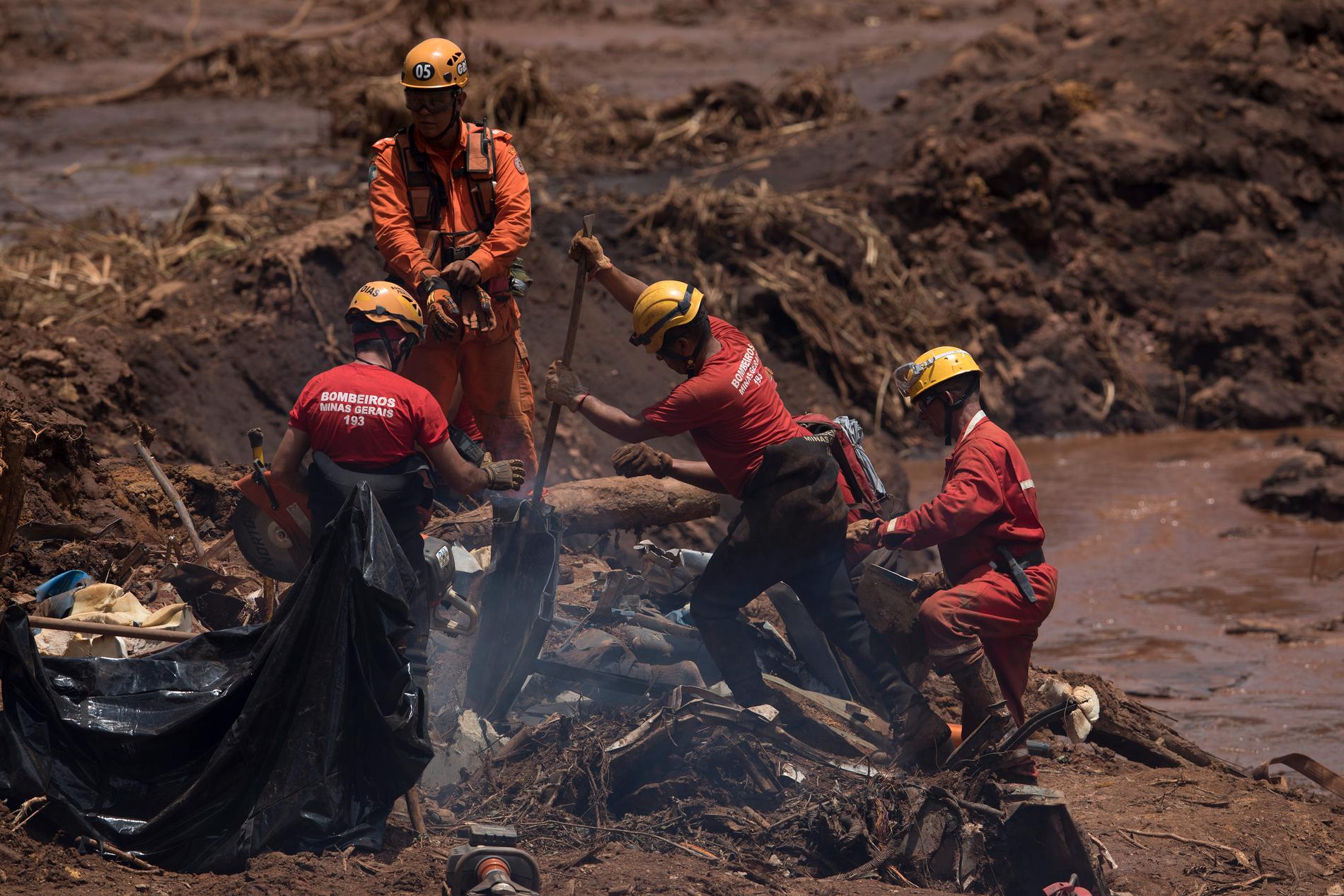 Räddningsarbetare letar efter offer i resterna av en bil som begravts i dammraset i Brumadinho, Brasilien.