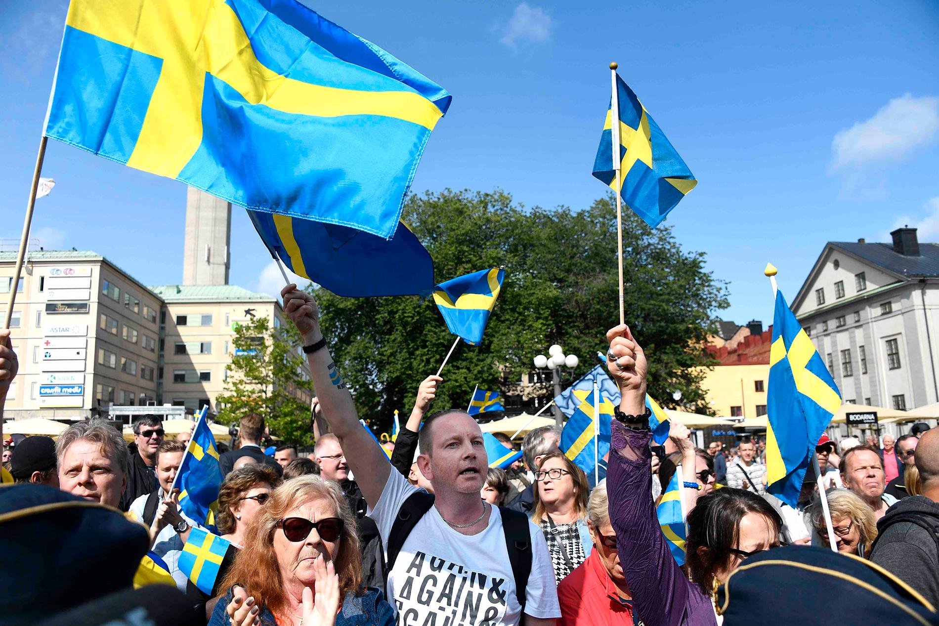 Sverigedemokrater skändar flaggan med skamlöshet på Medborgarplatsen, Stockholm, lördag 19 augusti.  
