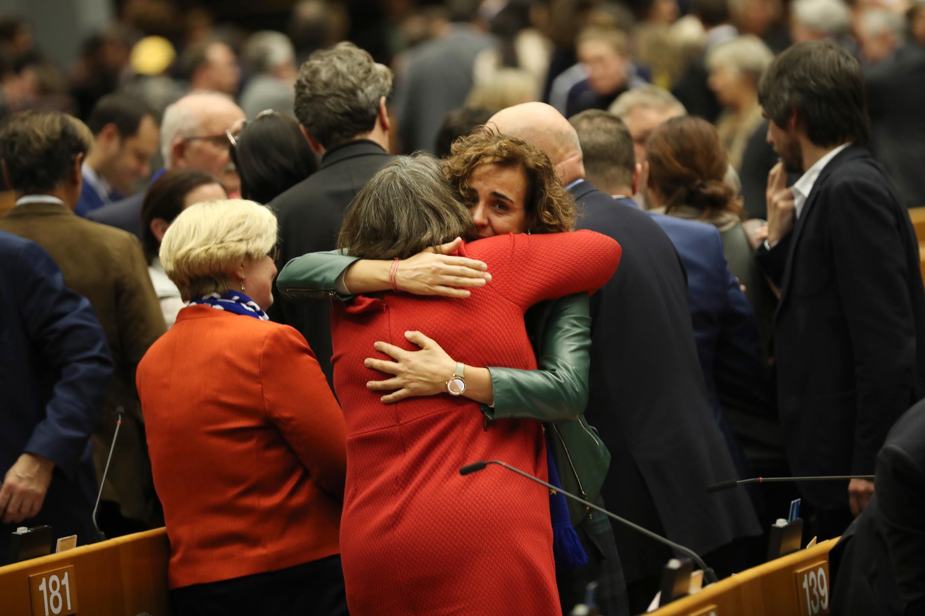 Brexitsörjande EU-parlamentsledamöter kramar om varandra efter att ha röstat om att godkänna Storbritanniens utträdesavtal.