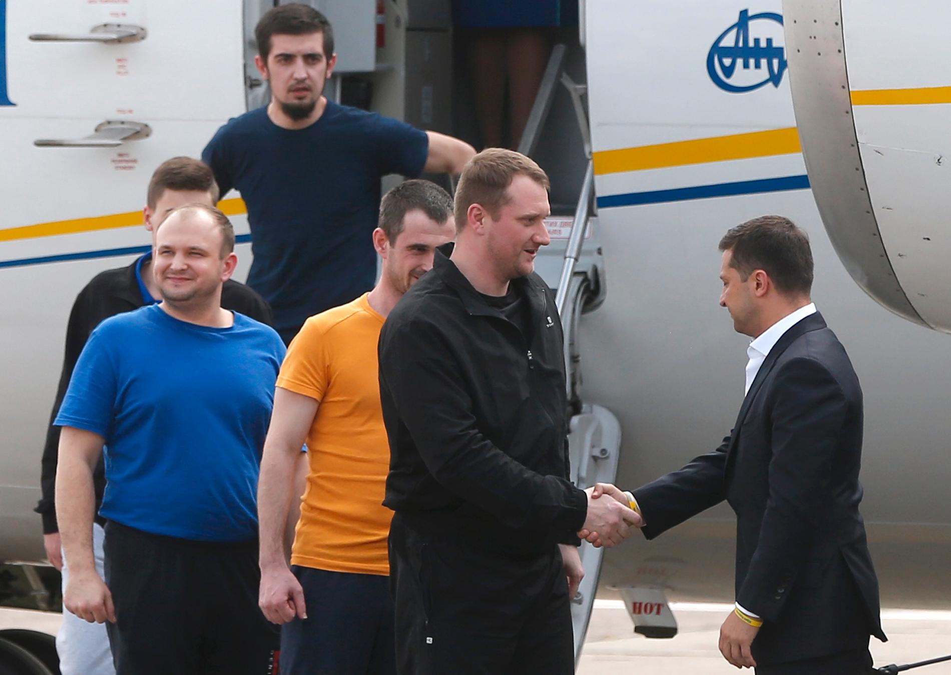 Ukrainas president Volodymyr Zelenskyj (längst till höger) välkomnar tidigare fångar tillbaka till Ukraina.