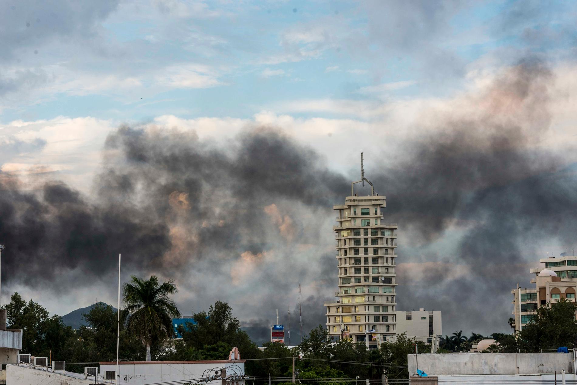 Rök från brinnande bilar ligger tung över Culiacán i Mexiko.