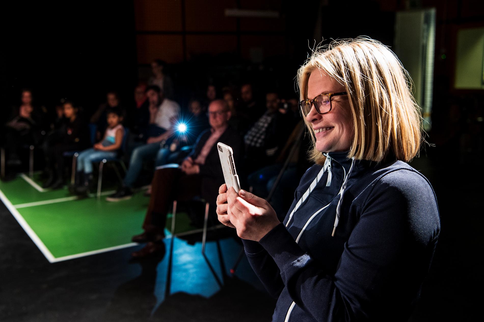 Läraren Minna Paananen sänder uppträdandet live på Facebook med hjälp av mobilen.