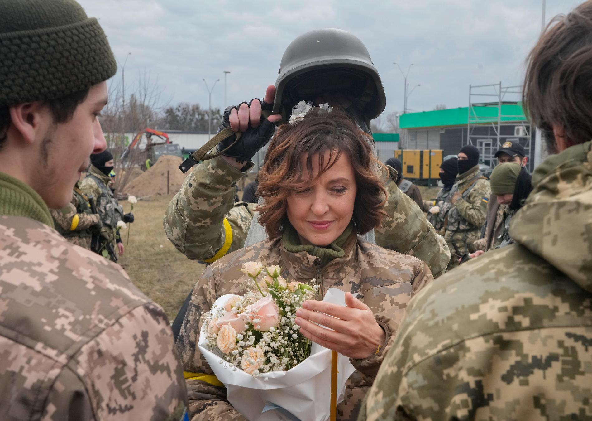 En soldat höll en hjälm över huvudet på bruden, som en bröllopstiara.