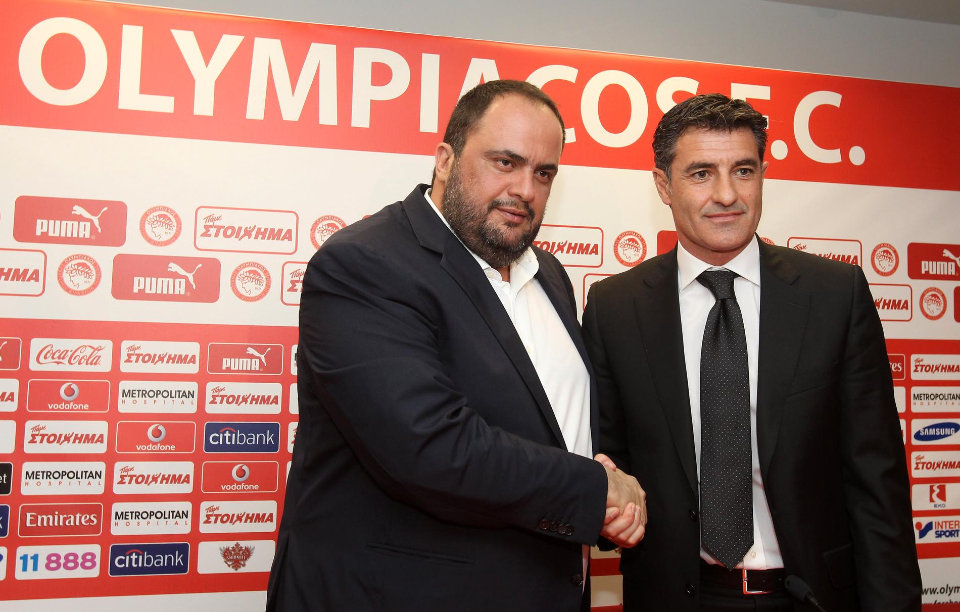 Olympiakos ordförande Vangelis Marinakis (till vänster) anklagas för matchfixning. På bilden skakar han hand med före detta tränaren Michel (till höger) 2013. Arkivbild.