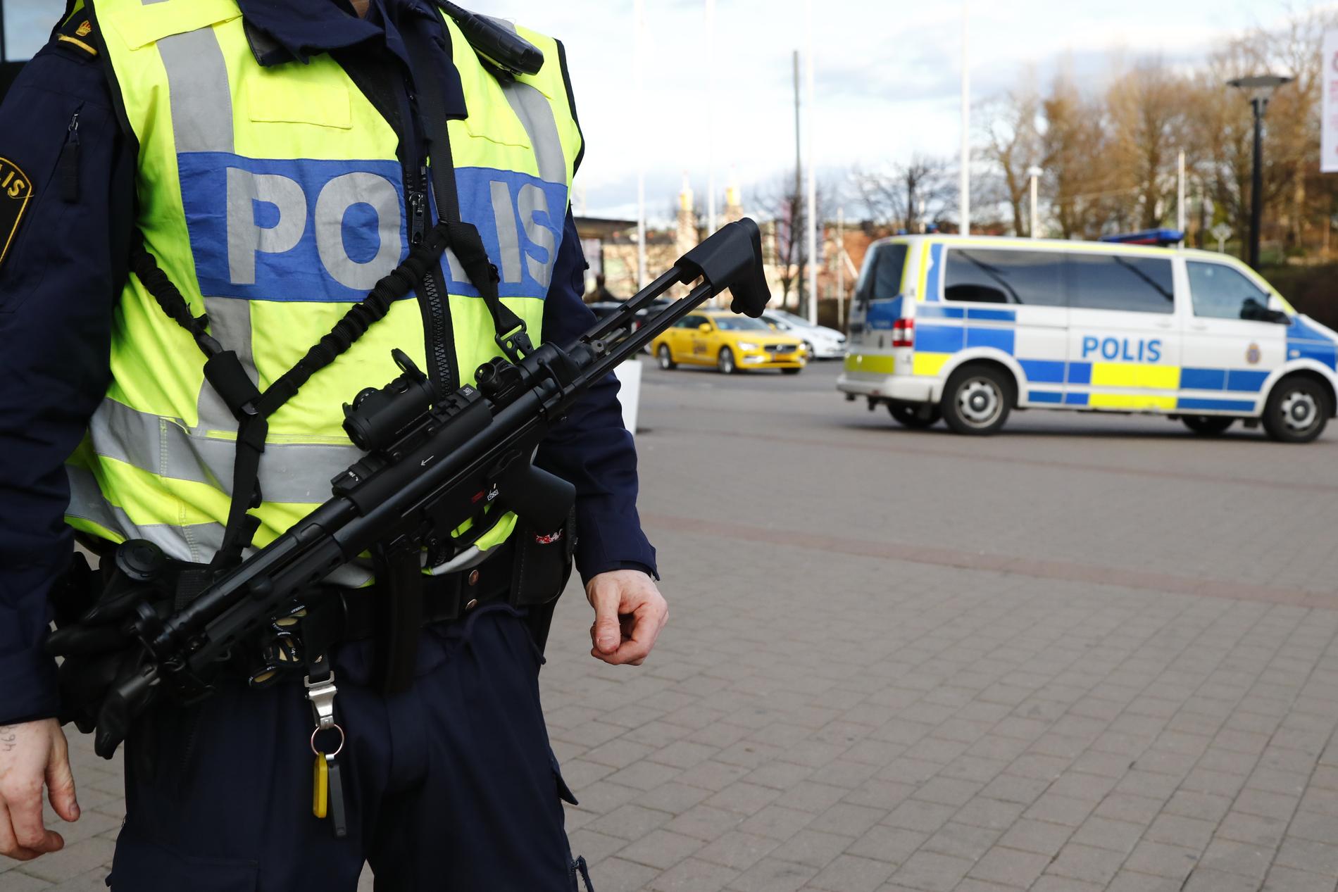En beväpnand polis och en polisbil utanför Svenska mässan i Göteborg.