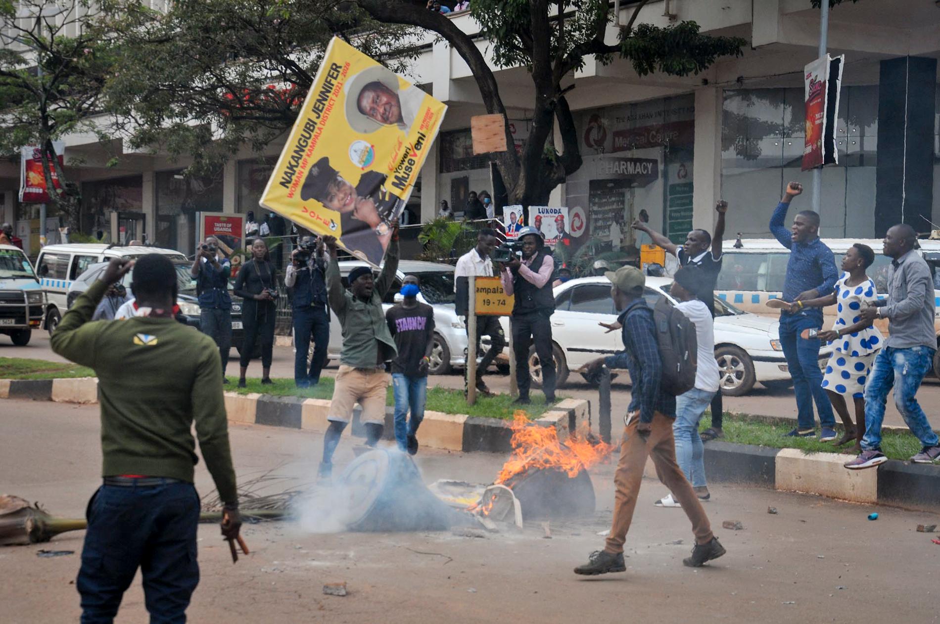 En anhängare till oppositionskandidaten Bobi Wine gör sig redo att elda upp en bild föreställande den sittande presidenten Yoweri Museveni i Kampala. Bild från i november.