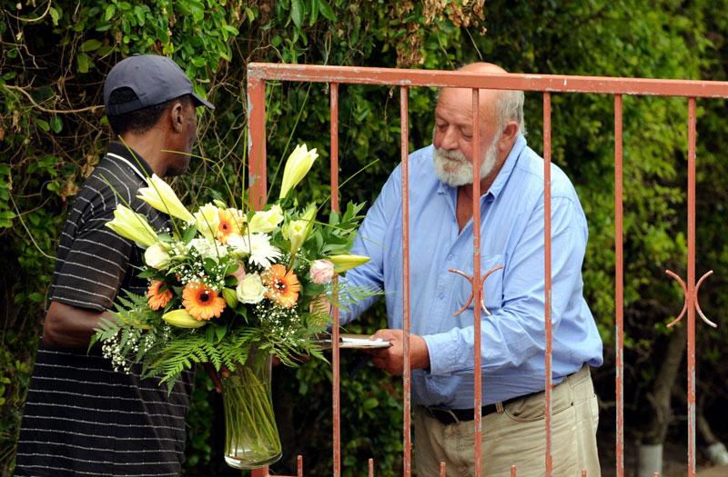 Samtidigt som häktesförhandlingen äger rum begravs Reeva Steenkamp på annat håll. Här får hennes pappa ta emot blommor utanför hemmet i Seaview.