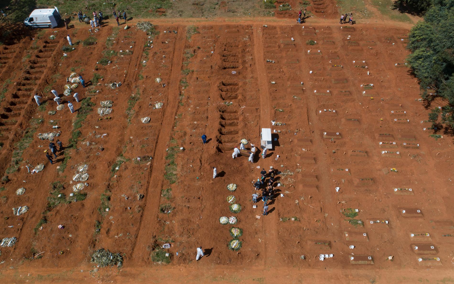 En kista med en person som avlidit i sviterna av covid-19 begravs på en gravplats i São Paulo.