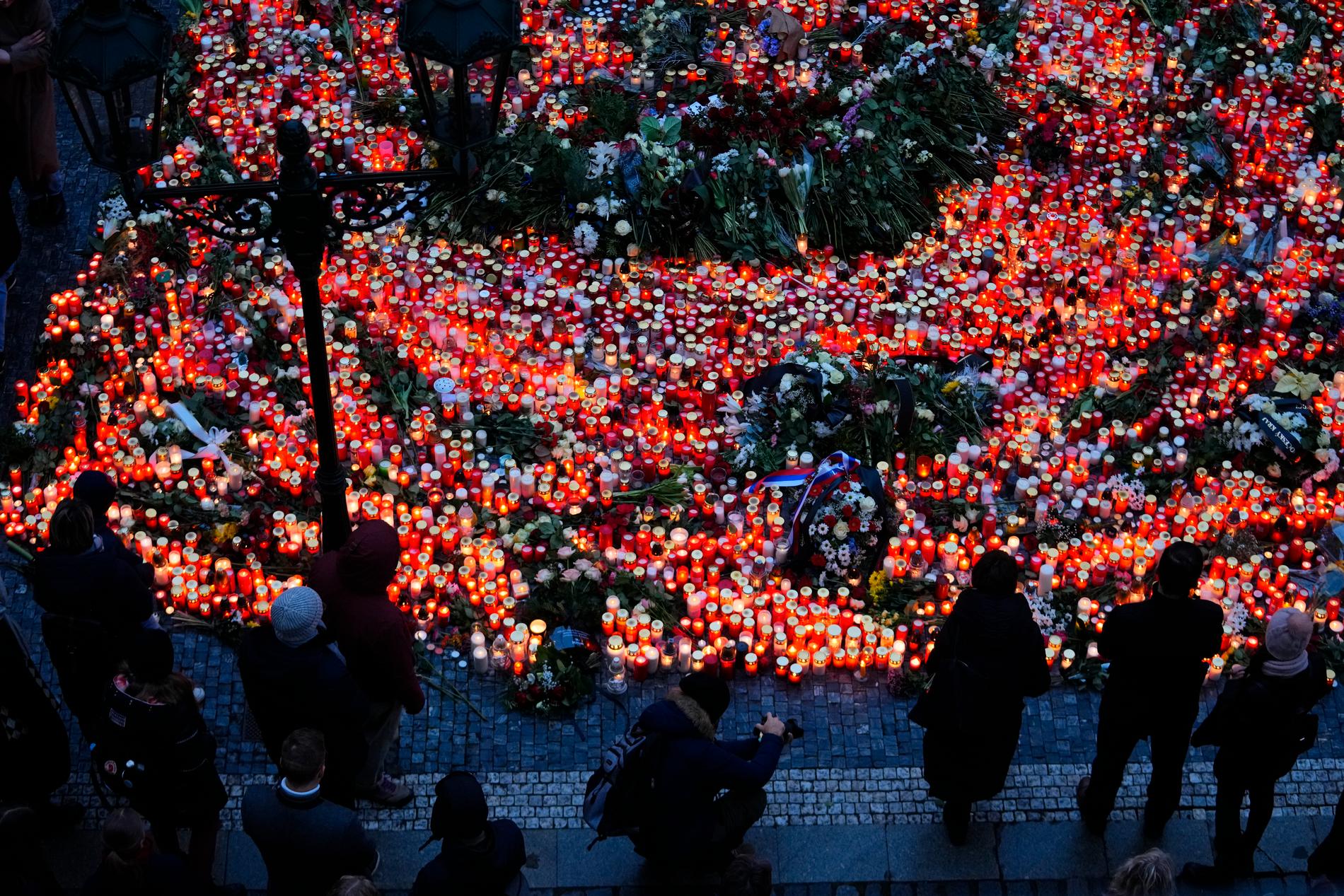 Människor i Prag tänder ljus för att hedra offren i masskjutningen.