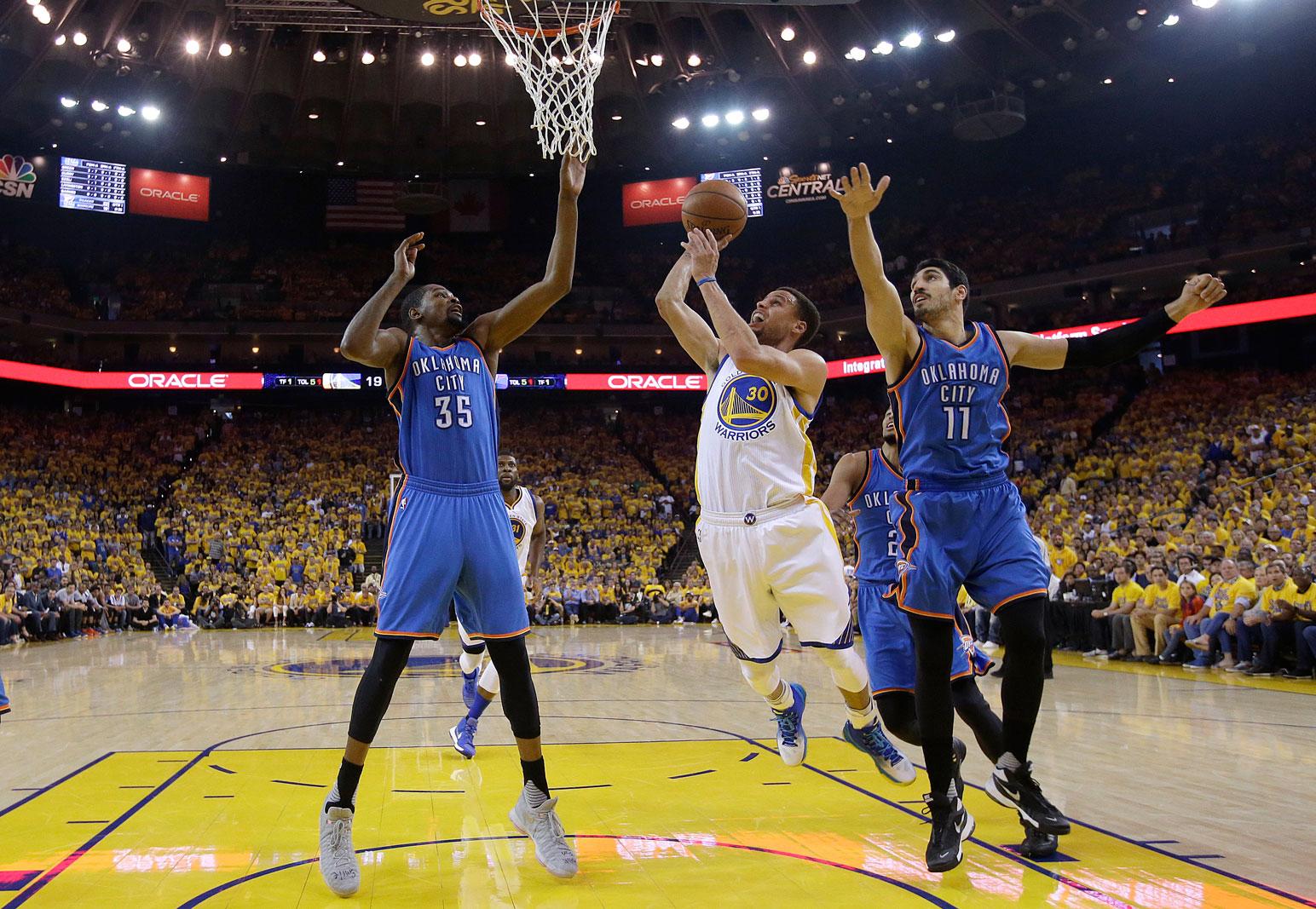 Stephen Curry skjuter mellan två spelare i Oklahoma.