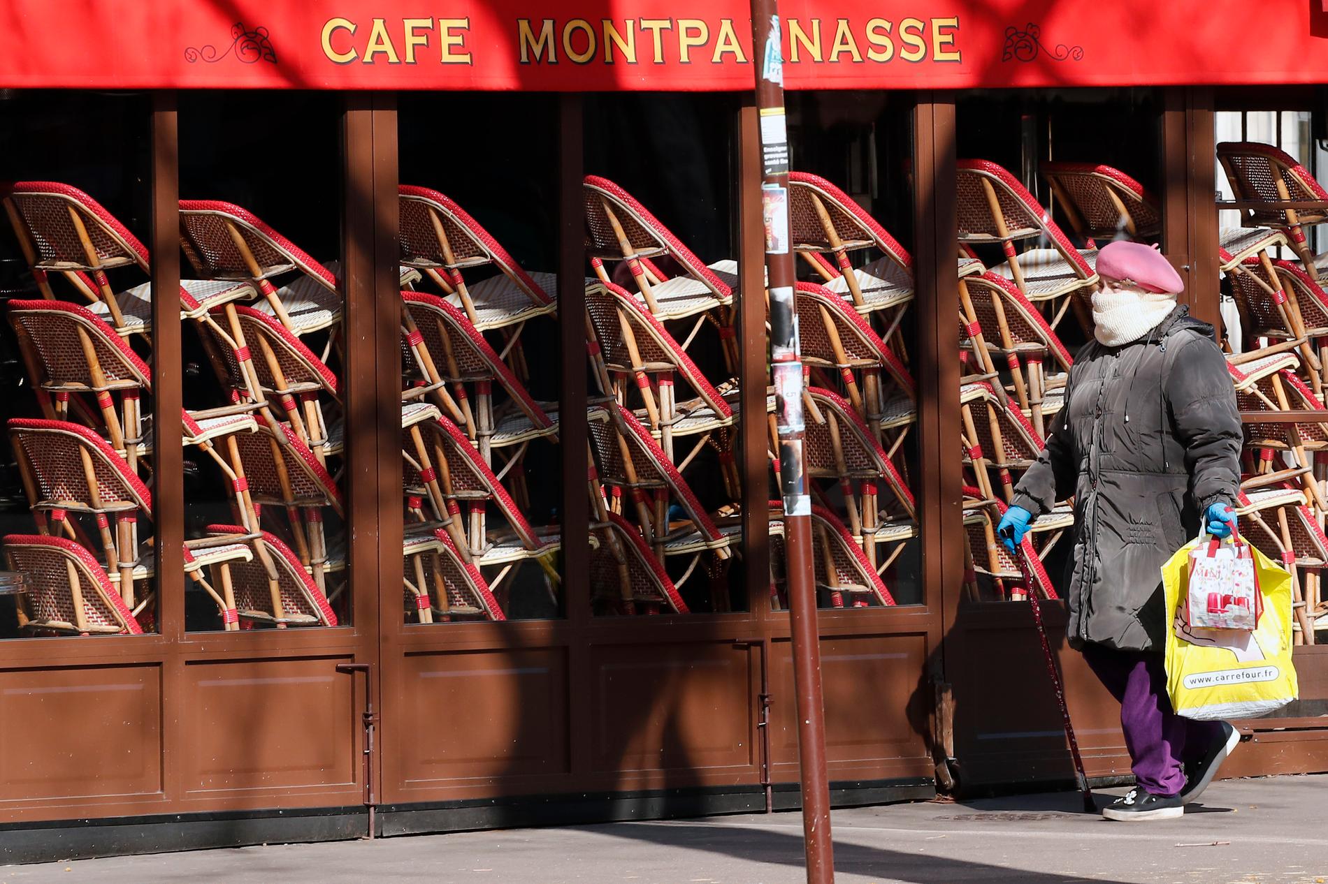 En kvinna går förbi en tillfälligt stängd restaurang i Paris. Arkivfoto.