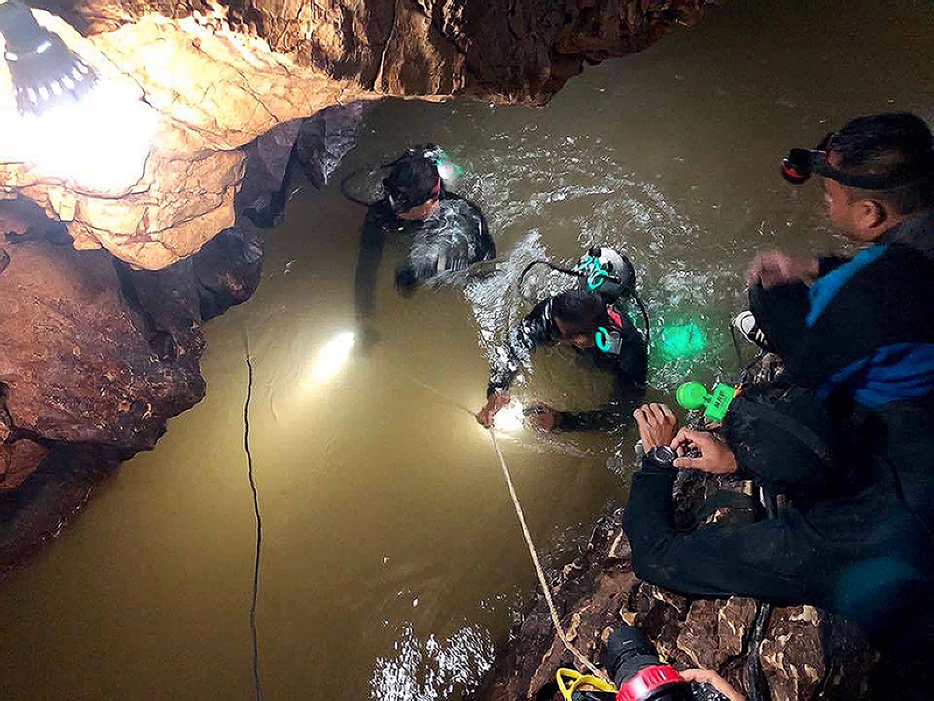 Dykare genomsöker en vattenfylld tunnel i Tham Luang-grottan under jakten på de försvunna pojkarna.