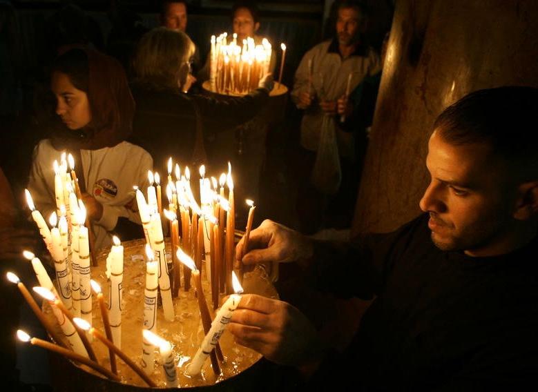 TRADITION Kristna pilgrimer tänder ljus i Födelsekyrkan i Betlehem på västbanken. Foto: AP