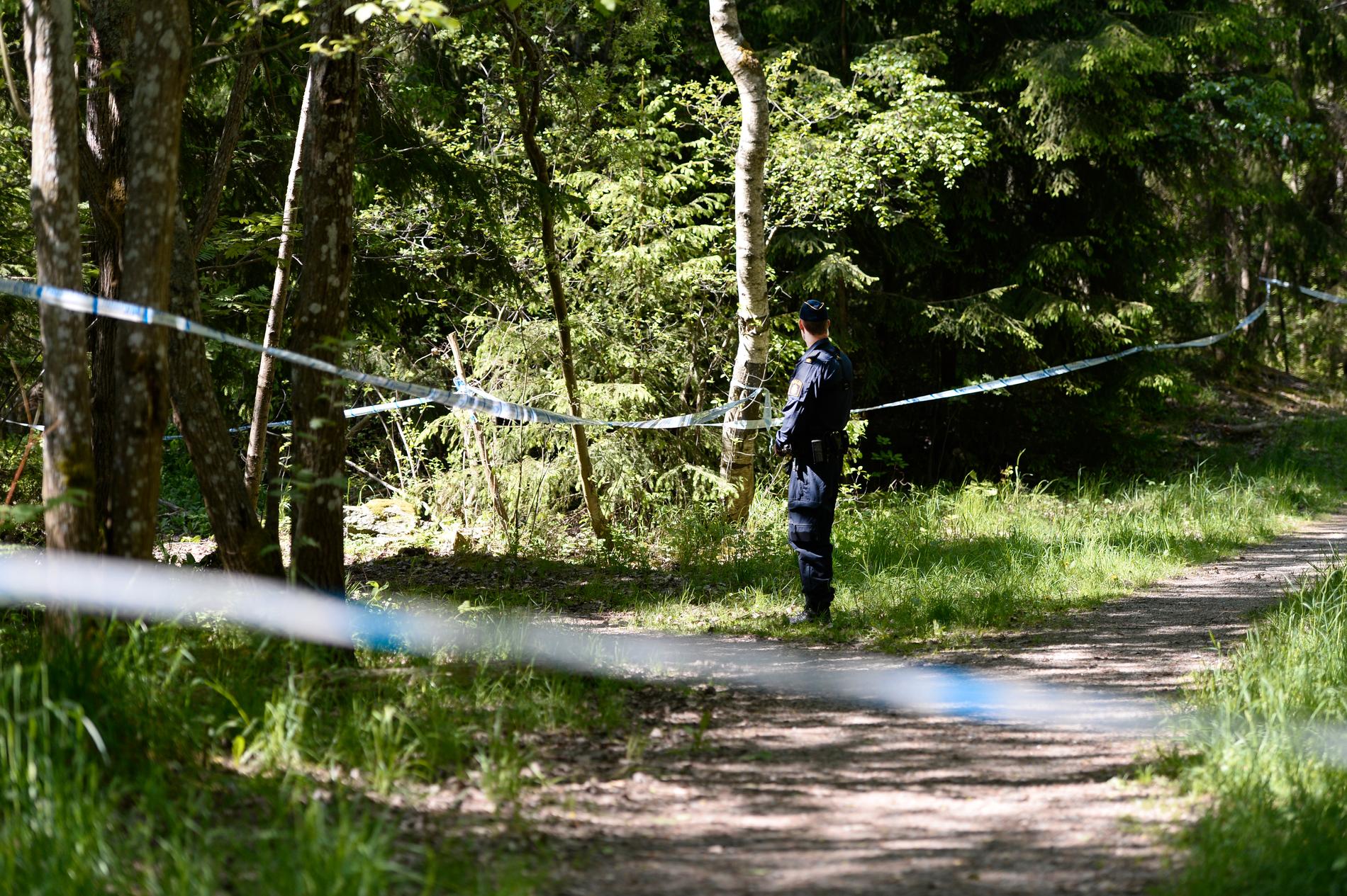 Polisavspärrningar i skogsområdet i Hökarängen där den unga kvinnan hittades död i slutet av maj 2016.