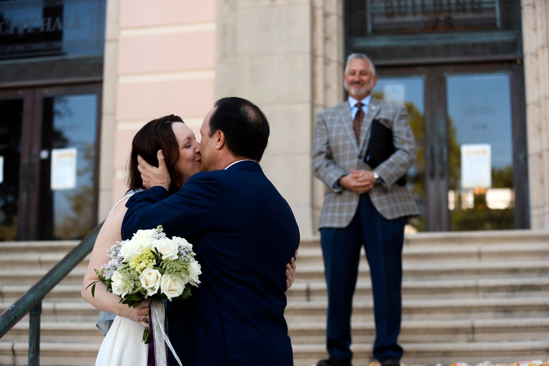 ST PETERSBURG, USA Gifta, trots allt. Kristen Shepherd och Todd Berman kysser varandra efter vigseln, som först ställts in på grund av coronaviruset, men som sen ändå kunde genomföras fast utomhus på stadshustrappan i St Petersburg, Florida. Fredag.