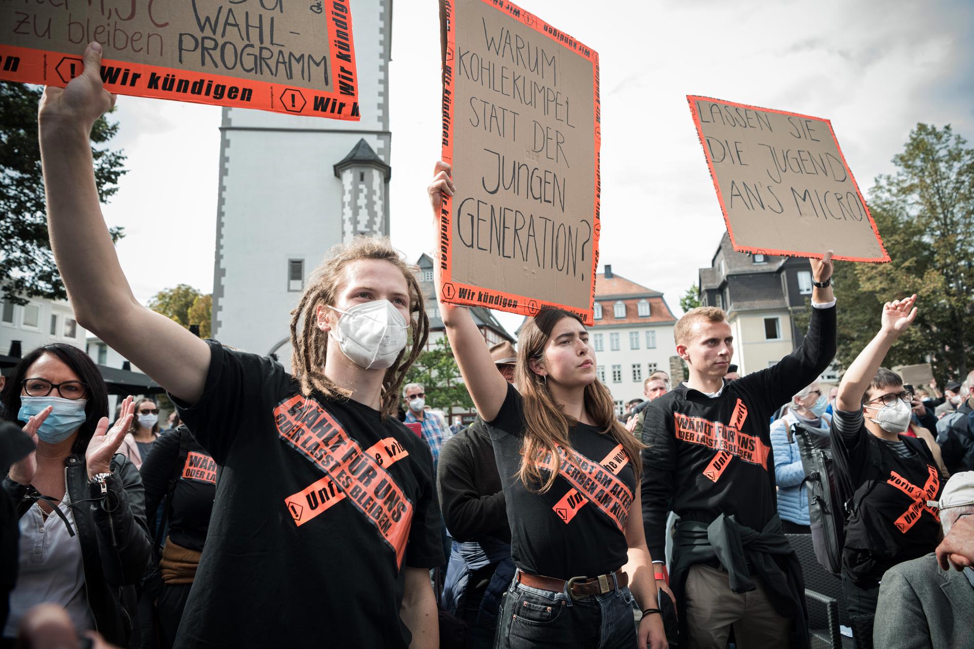 Miljöaktivister protesterar under Armin Laschets tal på torget i staden Giessen i delstaten Hessen.
