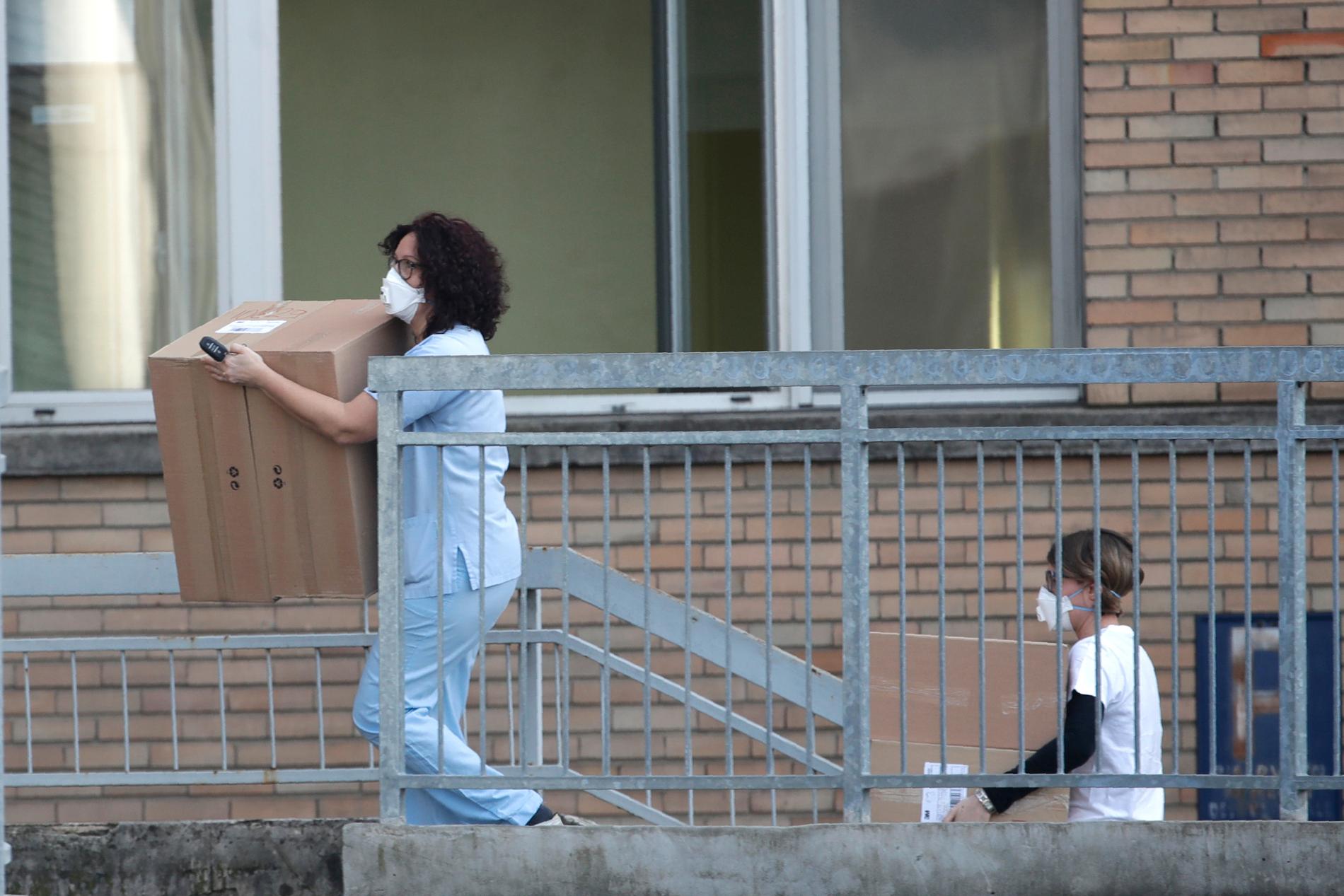 Sjukhuspersonal bär in lådor med utrustning till sjukhuset i Codogno. 