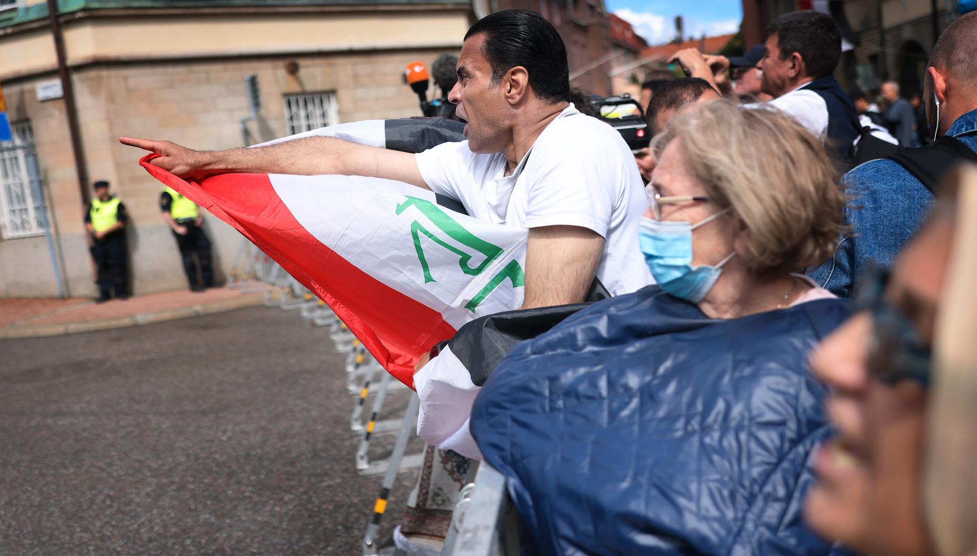 Demonstranter protesterar mot den planerade koranbränningen utanför Iraks ambassad i Stockholm.