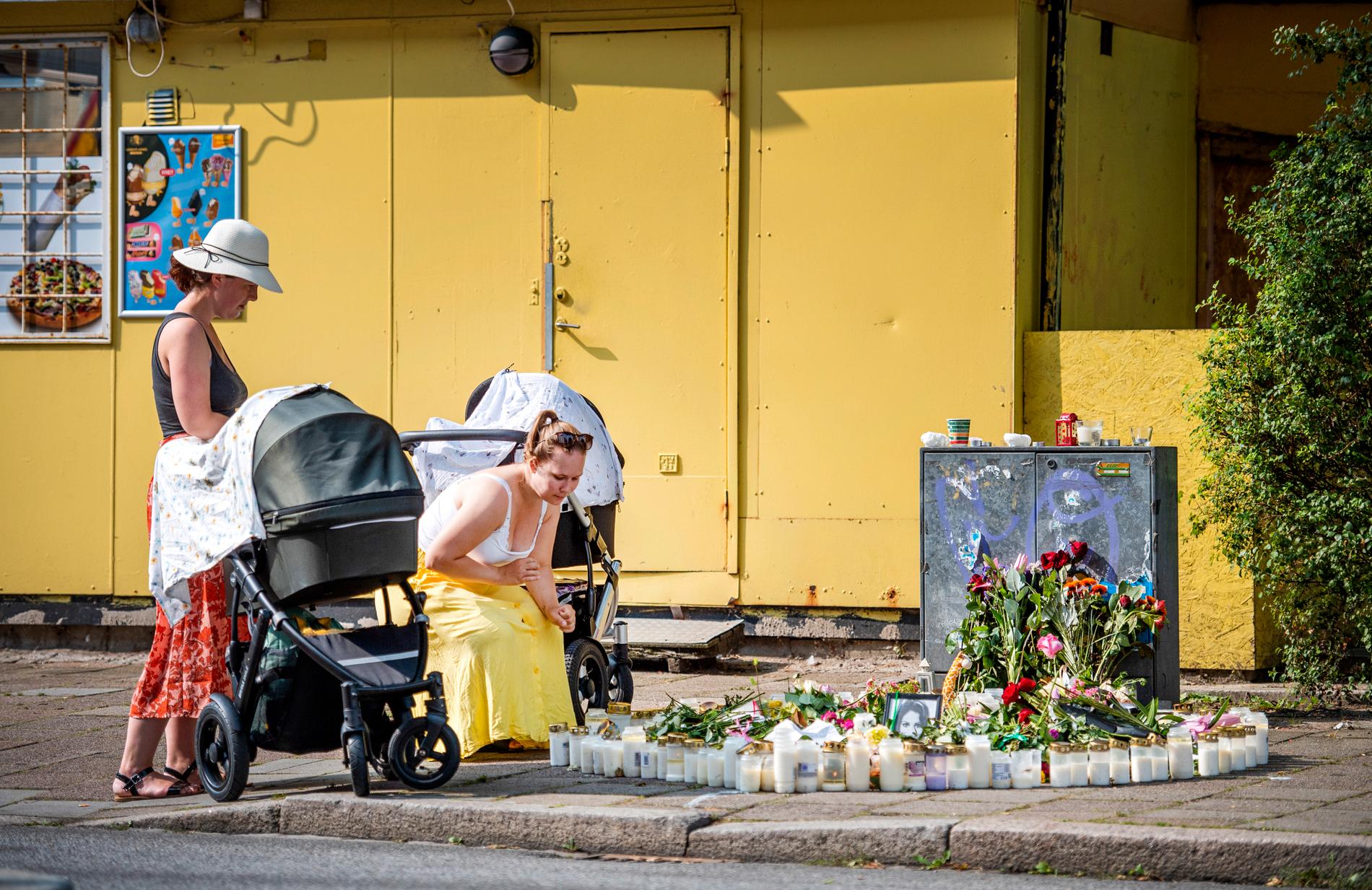 Småbarnsföräldrarna  Anna Änghede och Caroline Wahlgren tänder ljus vid mordplatsen. 