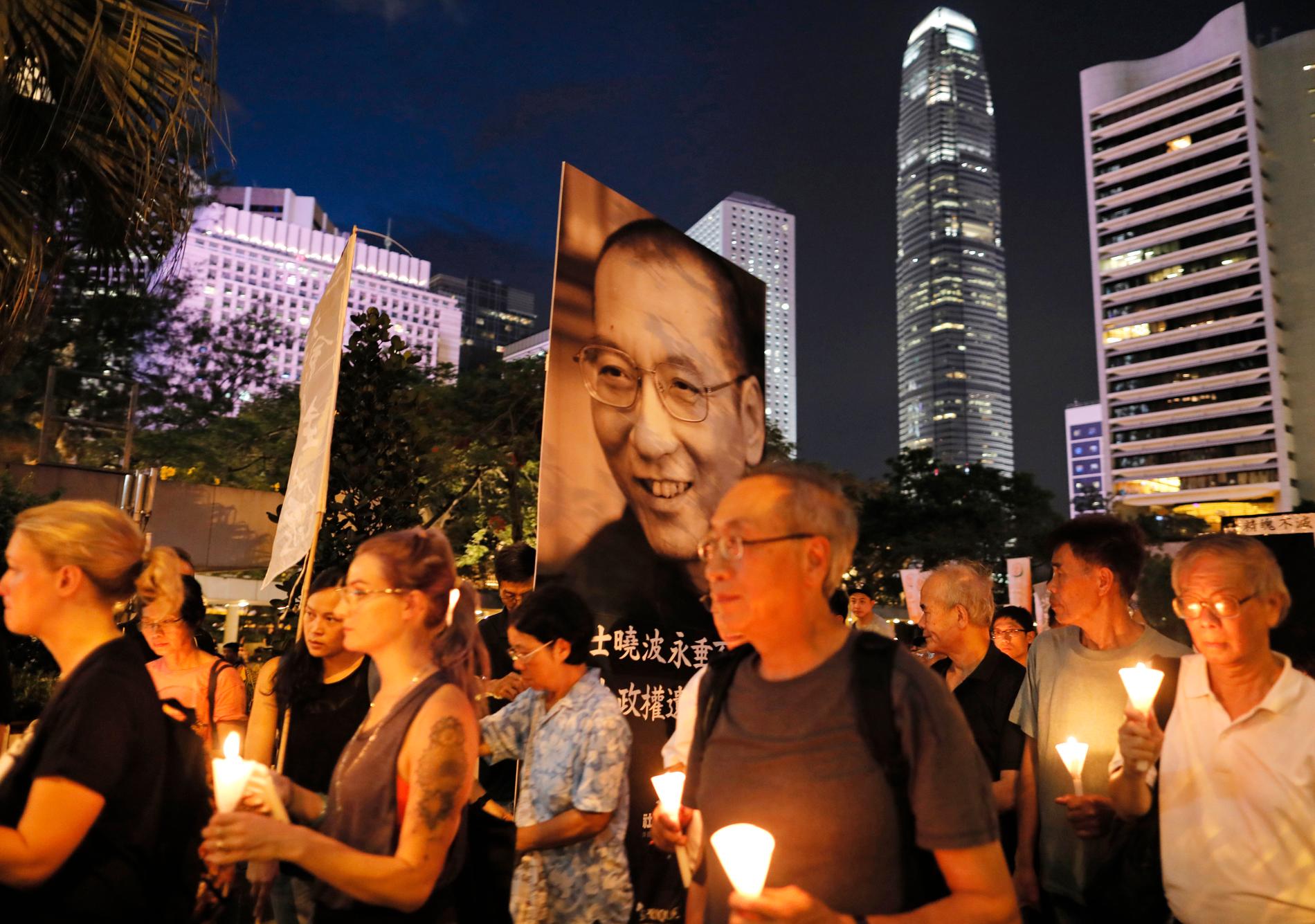 Med porträtt, politiska paroller och ljuslyktor tågade tusentals till Liu Xiaobos minne i Hongkong.